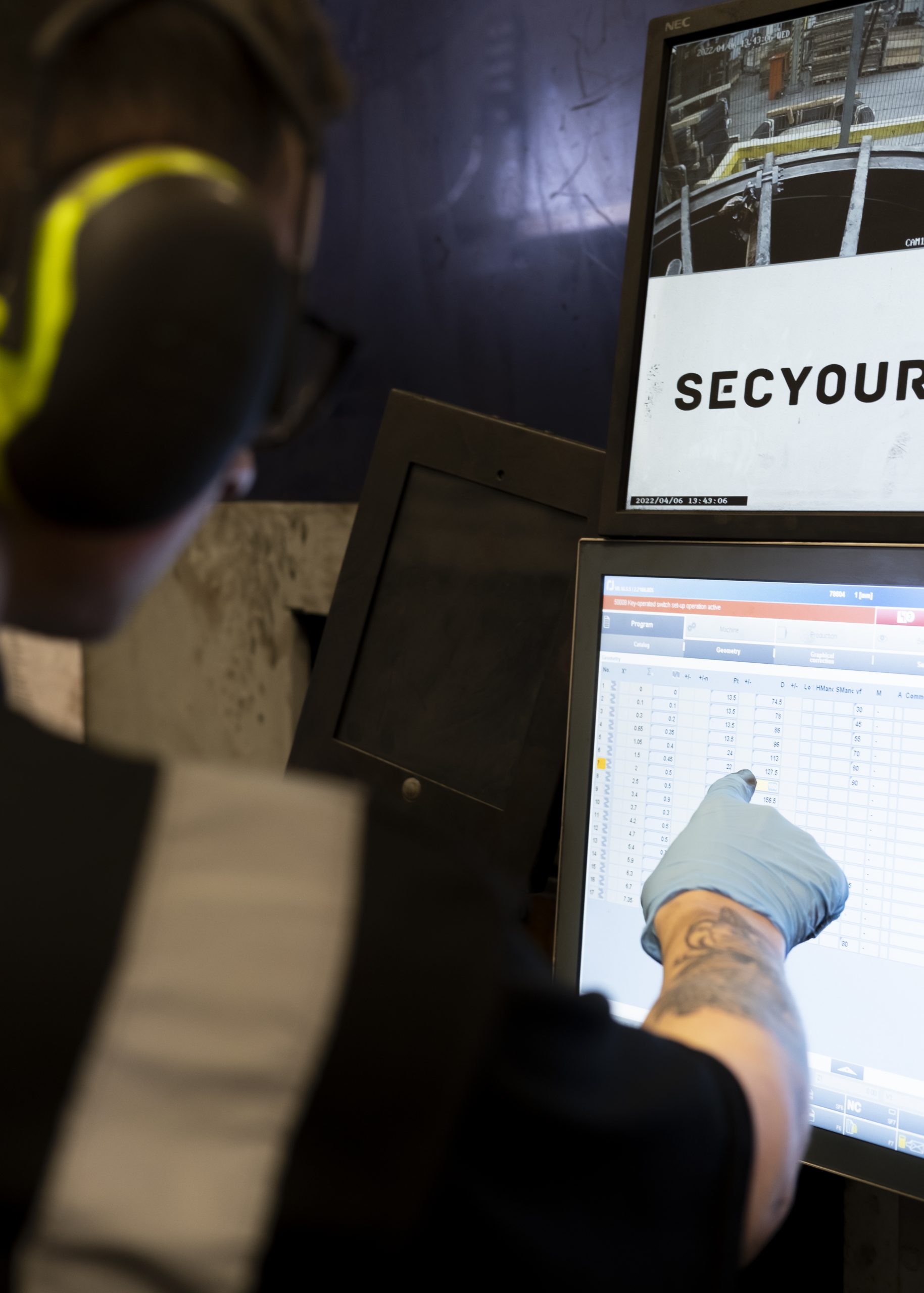 man touching the screen of a large manufacturing machine