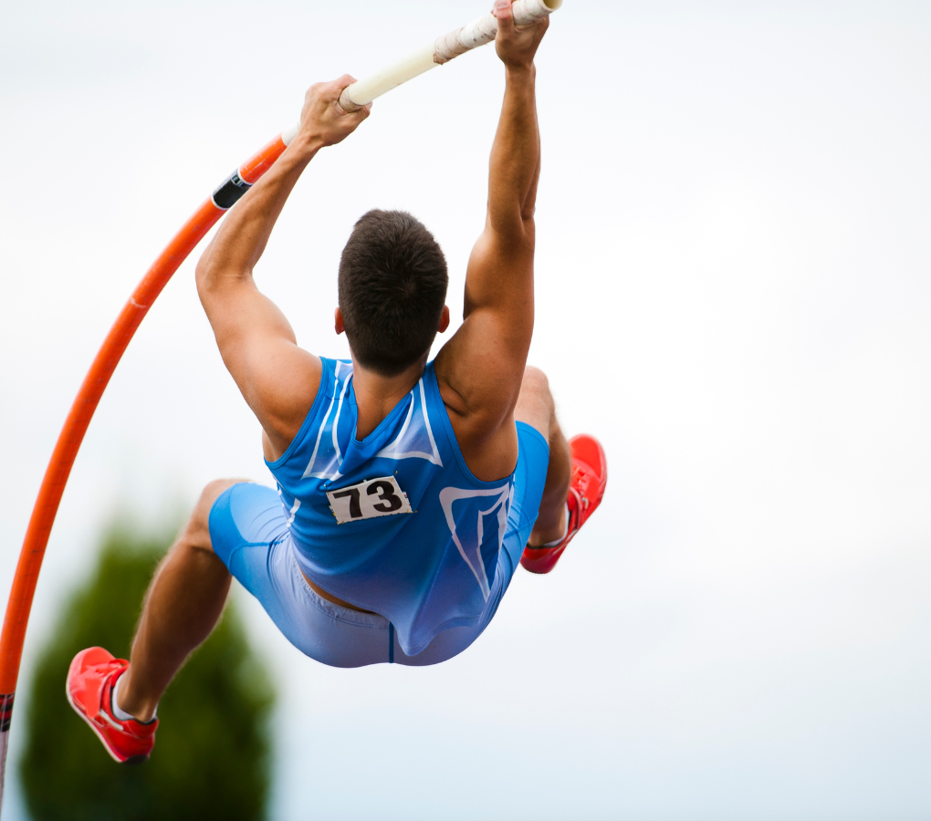 man jumping pole vault in blue outfit